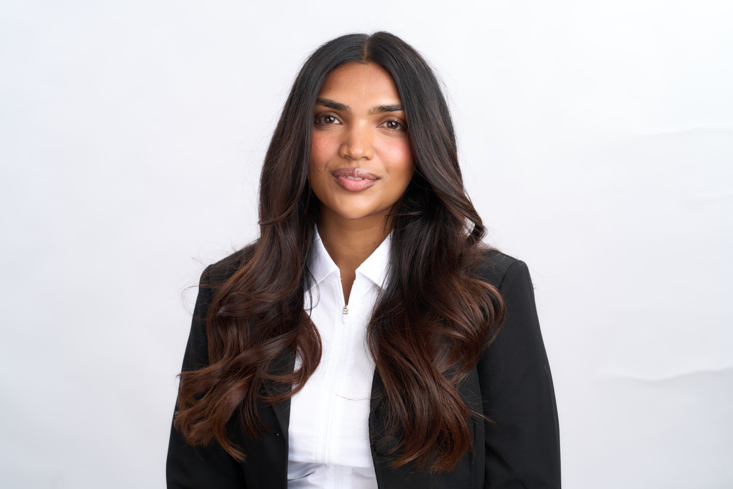 Delcy Pandya in a black blazer, smiling