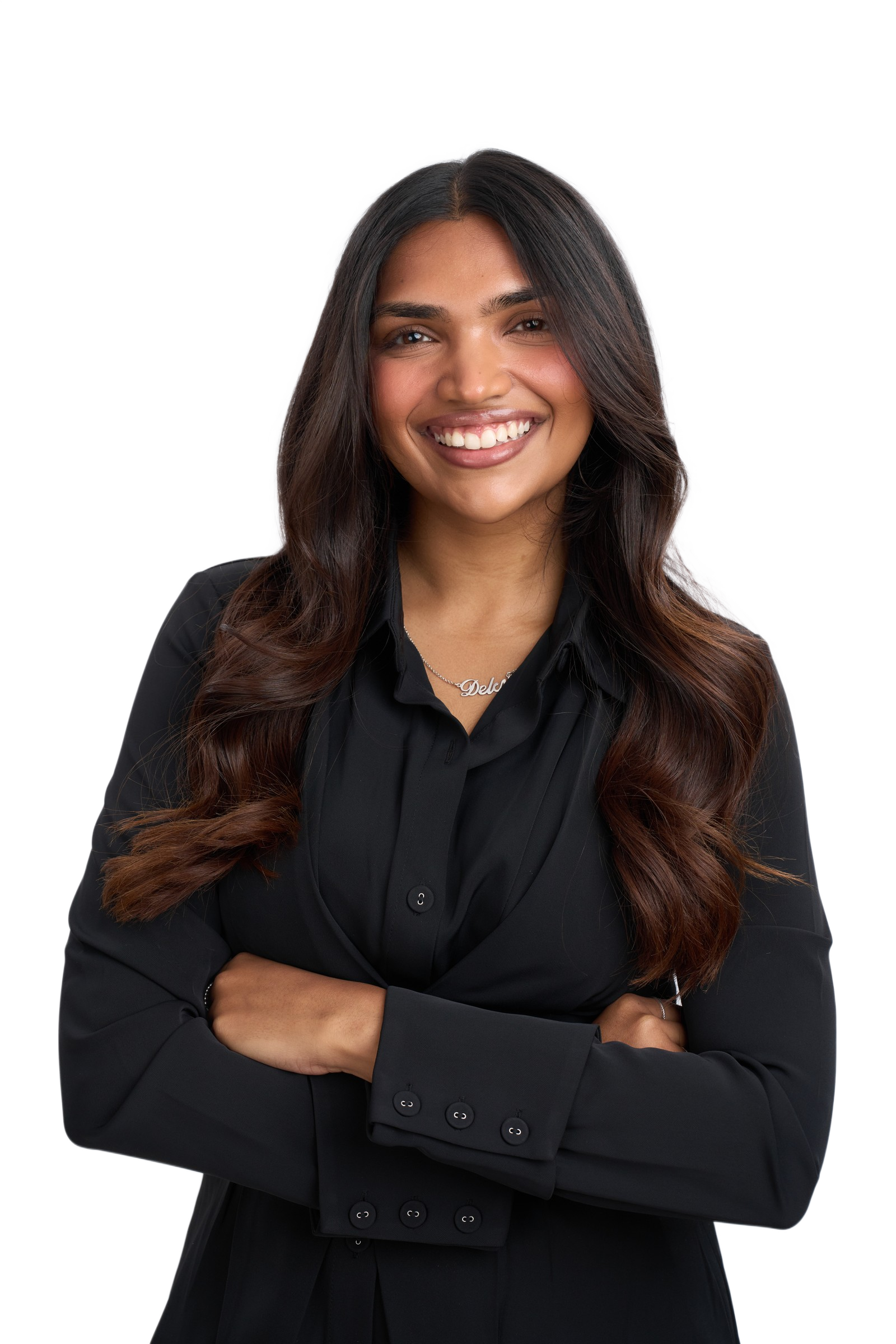 Delcy Pandya, smiling, arms crossed, in a black shirt.
